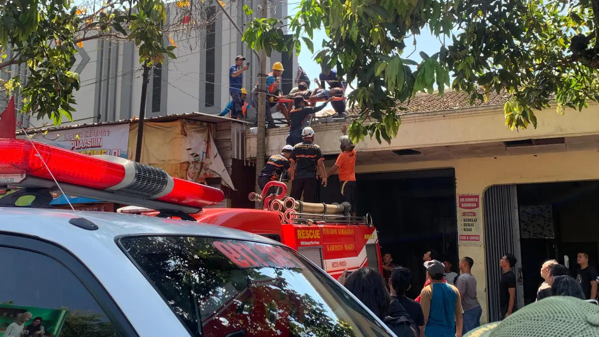 Petugas mengevakuasi Sukadi, 39, yang tersetrum saat memperbaiki atap kanopi Toko Murah, Kampung Kebonasri, Kelurahan Sragen Tengah, Minggu (29/3/2026).