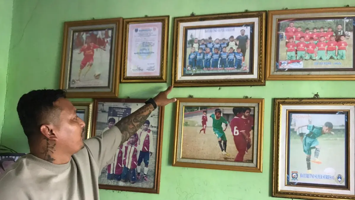 KELUARGA PEMAIN: Joko Sasongko memperlihatkan koleksi foto Dony Tri Pamungkas yang dipajang di rumah keluarga besarnya di Desa Gumukrejo, Kecamatan Teras, Kabupaten Boyolali. (ABDUL KHOFID/RADAR SOLO)