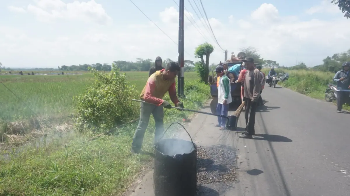 Petugas dari Dinas Pekerjaan Umum dan Penataan Ruang (DPU-PR) saat melakukan pemeliharaan jalan di ruas Karanganom-Janti beberapa waktu lalu. (Angga Purenda/Radar Solo)

