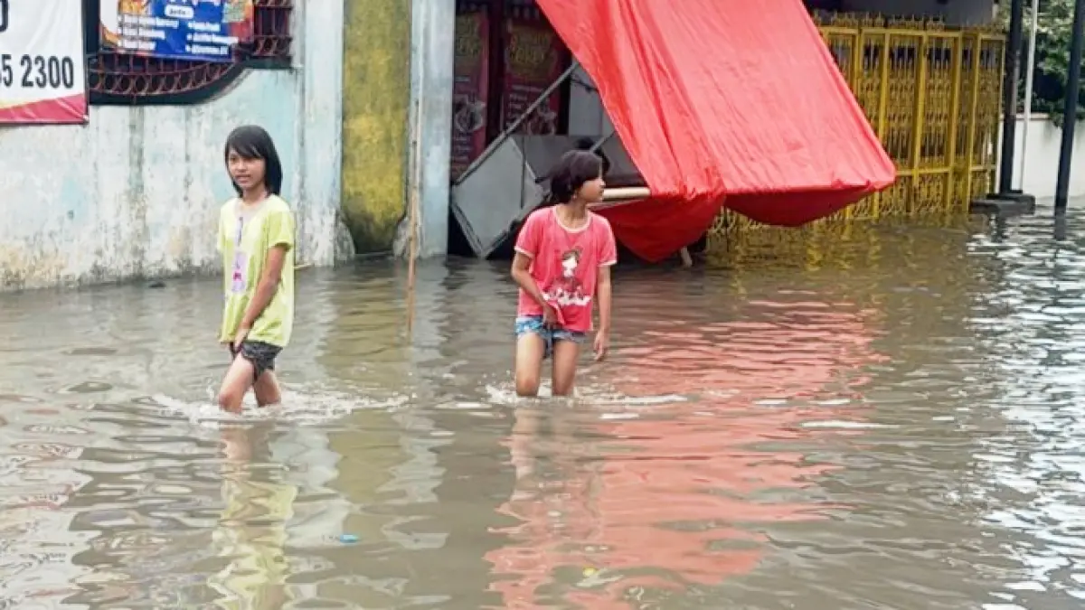 Banjir setinggi lutut anak-anak menggenangi permukiman di Sanggrahan, Kecamatan Grogol, Sukoharjo, Rabu pagi (15/4). (ARIEF BUDIMAN/RADAR SOLO)