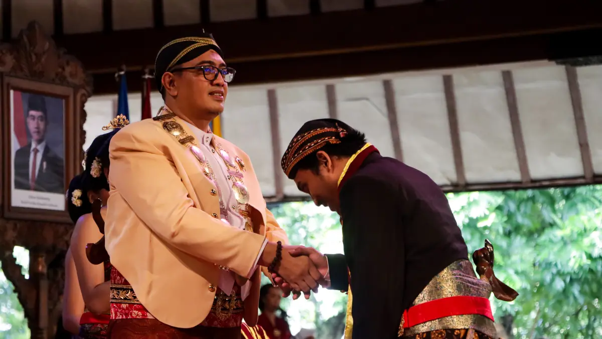 MEMBANGGAKAN: Rektor ISI Surakarta Bondet Wrahatnala memberikan selamat kepada salah satu wisudawan yang dinyatakan lulus dalam prosesi di Pendapa GPH Jayakusuma ISI Surakarta, Rabu (15/4). (M. IHSAN/RADAR SOLO)