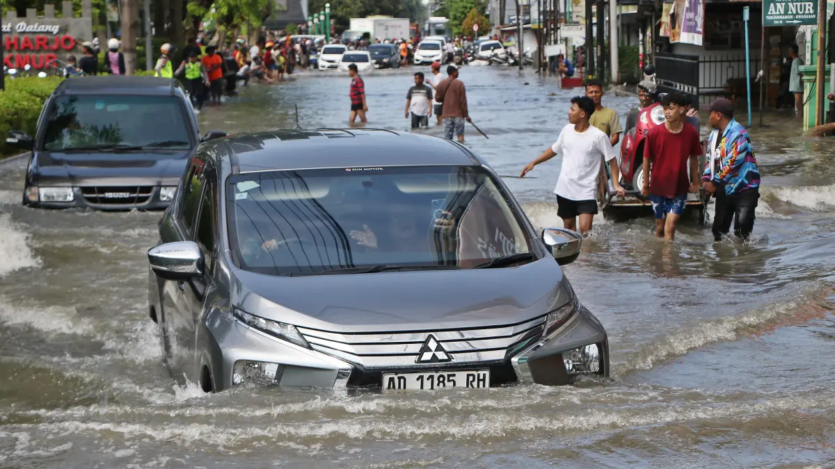 Sebuah  mobil menerjang banjir di perbatasan Solo-Sukoharjo, Rabu (15/4). (Arief Budiman/Radar Solo)
