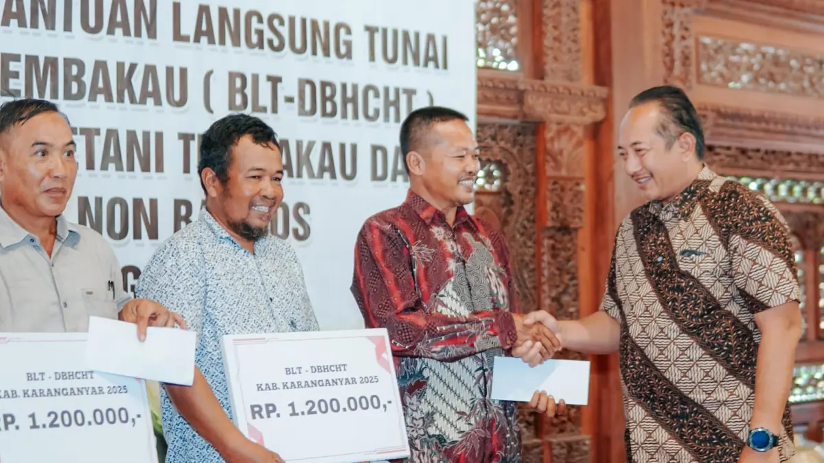 Bupati Karanganyar Rober Christanto menyerahkan BLT DBHCHT ke penerima, Kamis (16/4/2026). (Rudi Hartono/Radar Solo)