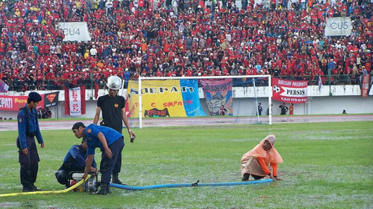Petugas tengah menyerap air yang menggenang karena turunnya hujan deras di laga Persis Solo di Stadion Manahan, 2006 silam. (DOK. RADAR SOLO).