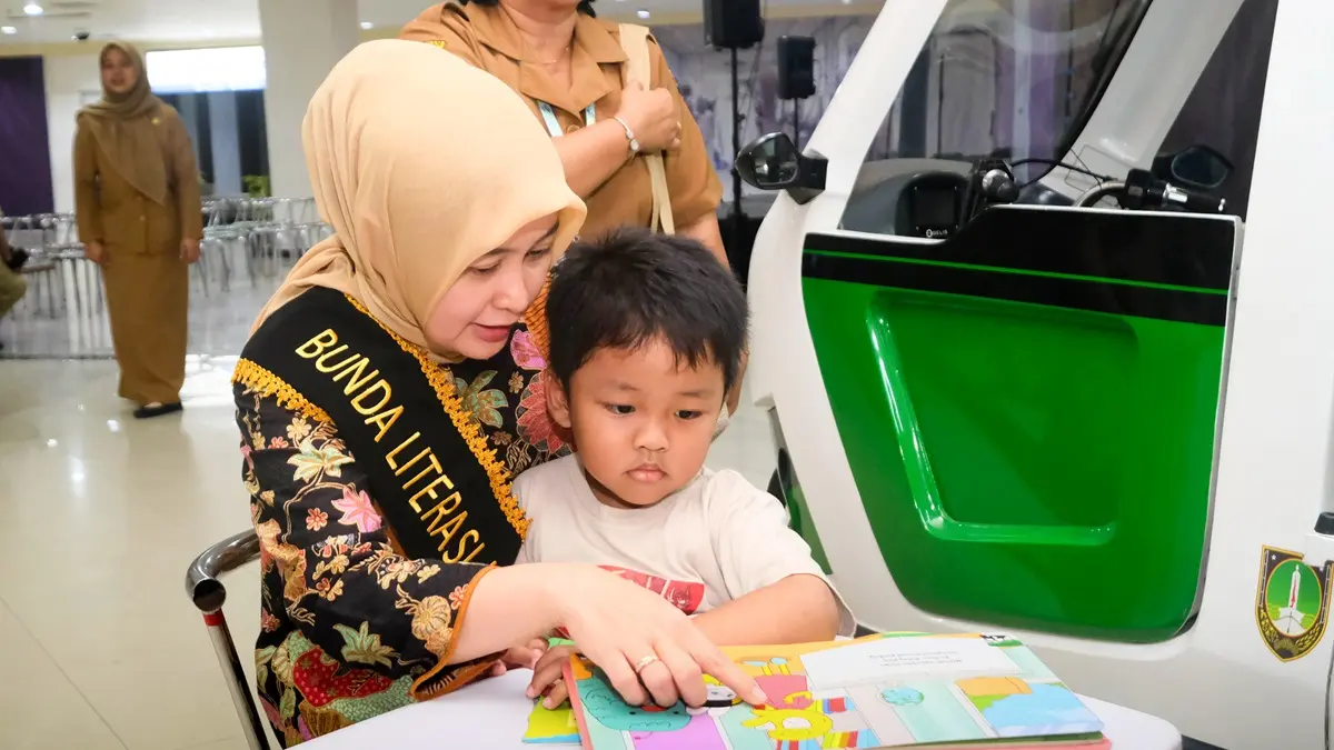 Bunda Literasi Kota Solo Venessa Winastesia membersamai anak-anak membaca koleksi buku Bemo Pustaka. (DOK. PRIBADI)