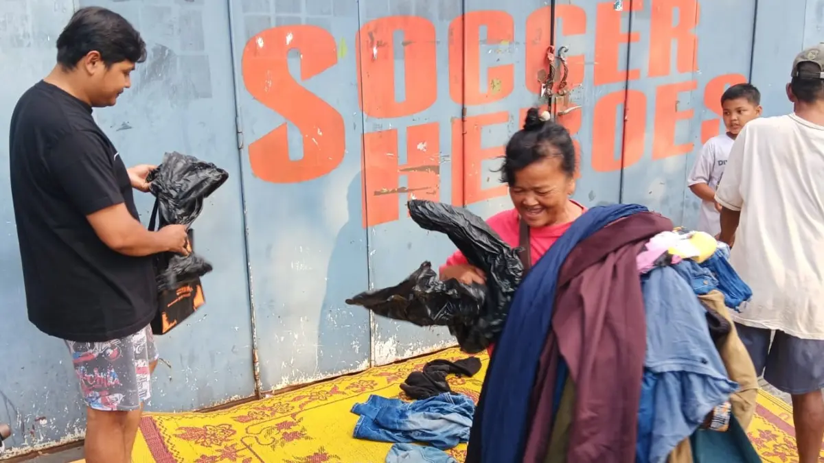 Warga membawa baju dari lapak baju gratis dalam gerakan Dapure Cah-cah di sudut Alun-alun Klaten. (Angga Purenda/Radar Solo)