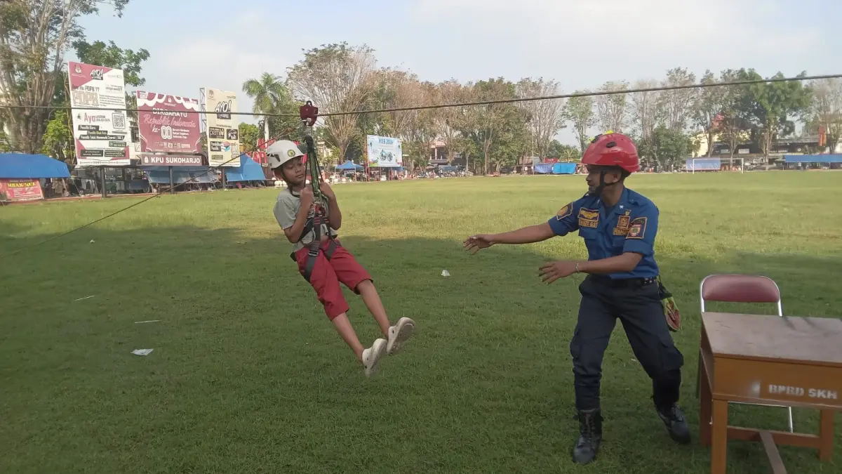 Keceriaan seorang anak saat menjajal flying fox saat perayaan Hari Kesiapsiagaan Bencana di Alun-Alun Satya Negara Sukoharjo, Minggu pagi (26/4). (Iwan Kawul/Radar Solo)