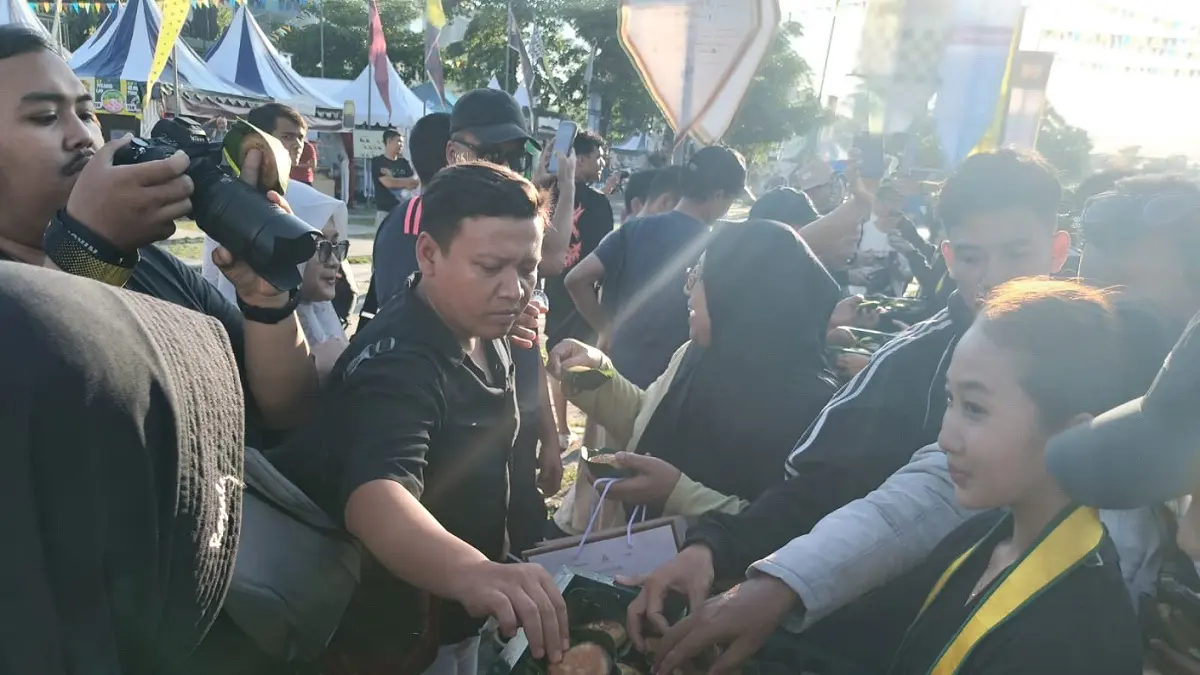 Masyarakat mengambil apam yang dibagikan pada abdi dalem Pura Mangkunegaran dalam acara pembukaan Mangkunegaran MakaN-MakaN 2026 pada Jumat (1/5/2026). 