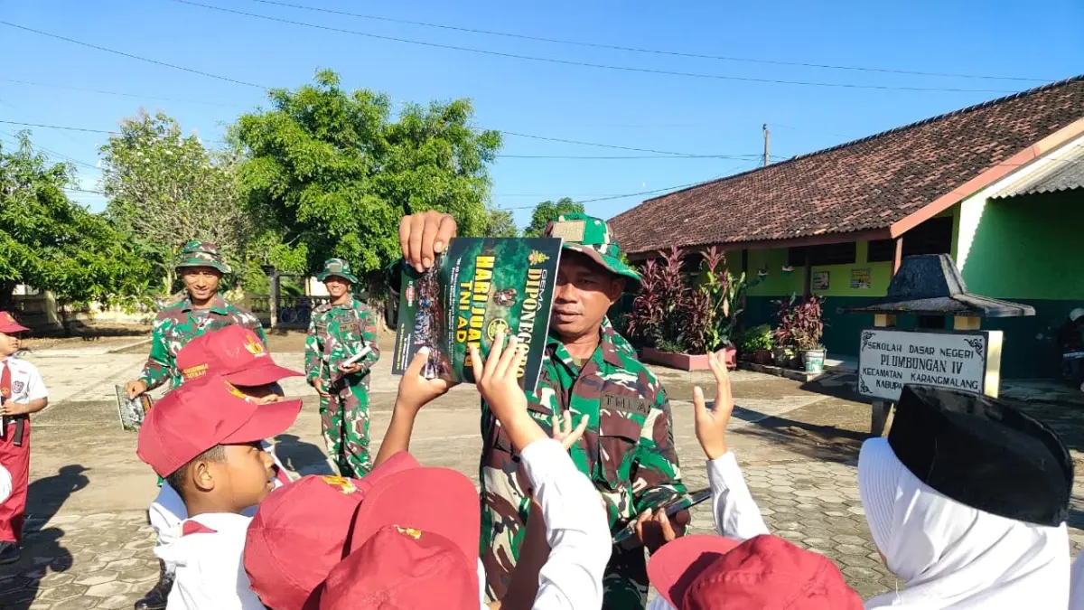 Siswa SDN Plumbungan IV menerima buku dari satgas TMMD di Desa Puro, Kecamatan Karangamlang, Sragen, Sabtu (3/5/2026). (Ahmad Khairudin/Radar Solo)
