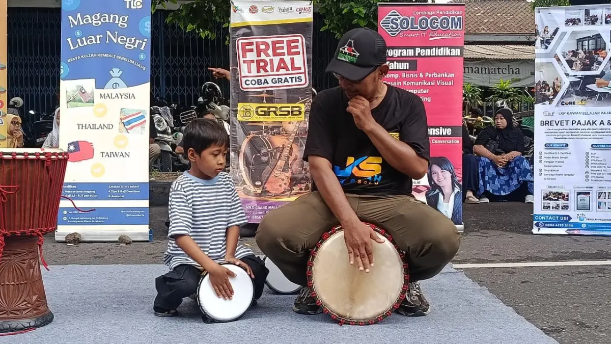 TERTARIK: Anak-anak tengah mencoba-coba bermain alat musik dalam Festival Pendidikan Non Formal yang digelar di CFD, Minggu (3/5/2026). (ALFIDA NURCHOLISAH/RADAR SOLO)