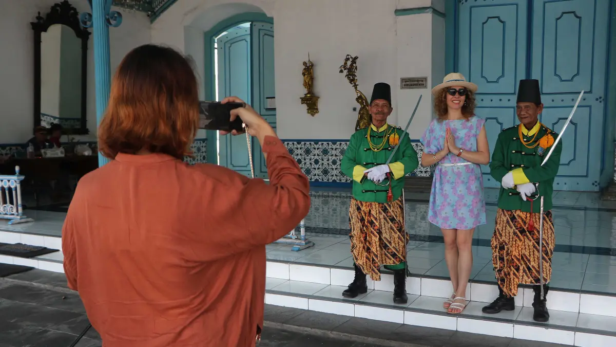 Wisatawan asing berfoto bersama abdi dalem Keraton Kasunanan Hadinigrat saat momentum libur long weekend memperingati Kenaikan Isa Almasih, Kamis (14/5). (ARIEF BUDIMAN/RADAR SOLO)