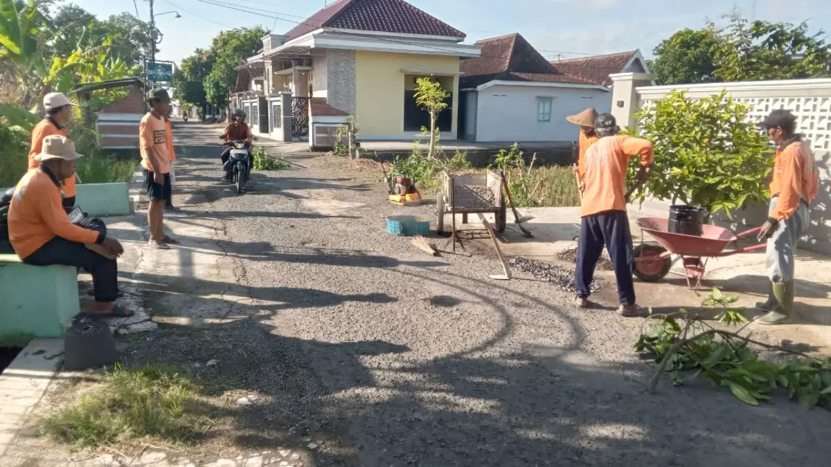 Warga RT 06 Desa Krajan, Kecamatan Gatak menambal jalan rusak dengan aspal yang biayanya dari hasil patungan atau swadara, Minggu (17/5). (Iwan Kawul/Radar Solo)