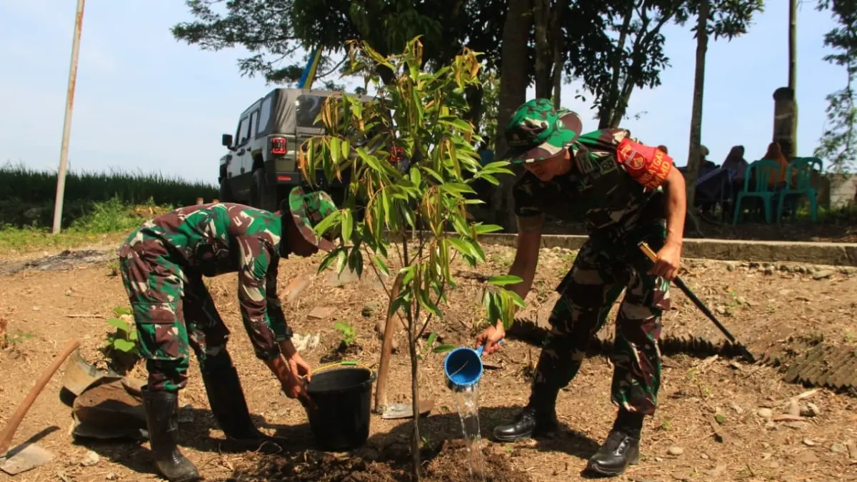 Dandim 0725/Sragen Letkol Inf Dindin Rohidin (kanan) menanam bibit durian di lokasi sumur bor TMMD di Desa Pelemgadung, Kecamatan Karangmalang, Selasa (19/5/2026). (Ahmad Khairudin/Radar Solo)