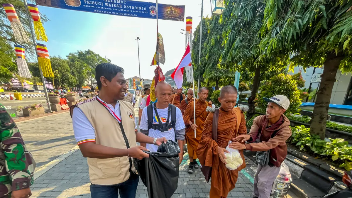 BERBAGI: Seorang penjual bakpao memberikan barang jualannya kepada biksu yang tengah melintas melakukan tudong. (M. IHSAN/RADAR SOLO)