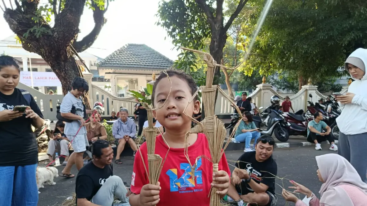 Seorang bocah diajari cara membuat wayang suket saat workshop di Solo CFD Jalan Slamet Riyadi, Minggu (31/5). (ALFIDA NURCHOLISAH/RADAR SOLO)
