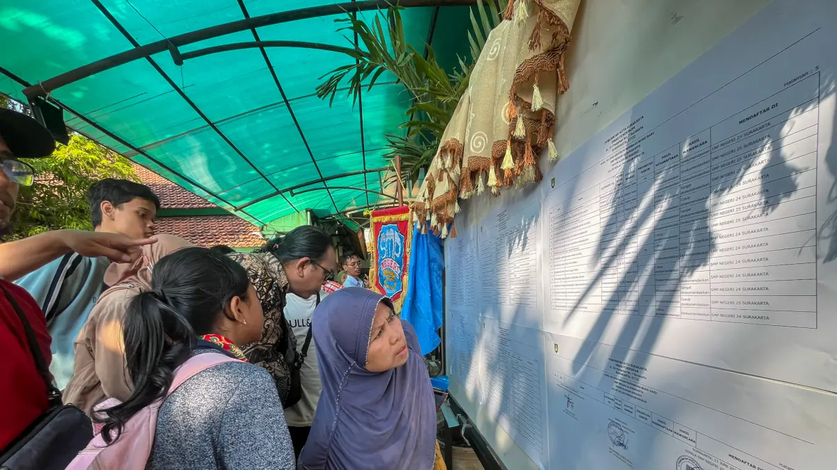 Orang tua siswa melihat pengumuman penerimaan siswa SMPN PK Solo, Rabu (3/6). (M IHSAN/RADAR SOLO)