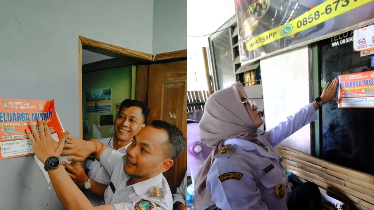 Wali Kota Solo Respati Ardi dan Wawali Astrid Widayani menempel stiker di rumah keluarga miskin penerima bantuan sosial. (Humas Pemkot Solo)