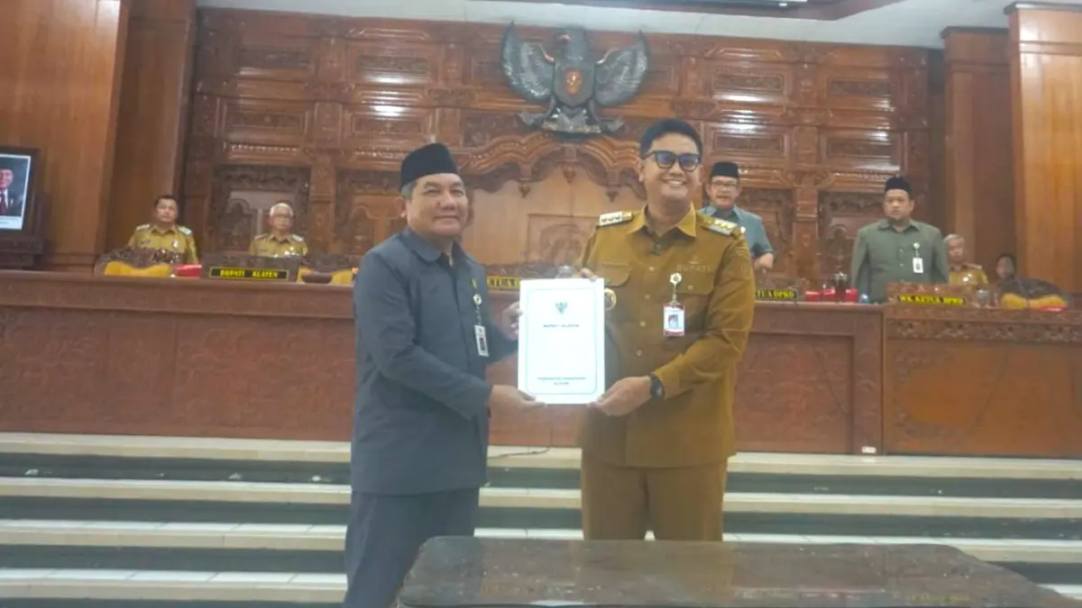 Bupati Klaten Hamenang Wajar Ismoyo menyerahkan dokumen dua raperda ke Wakil Ketua DPRD Klaten Bahtiar Joko Widagdo dalam rapat paripurna, Senin (8/6/2026). (Angga Purenda/Radar Solo)