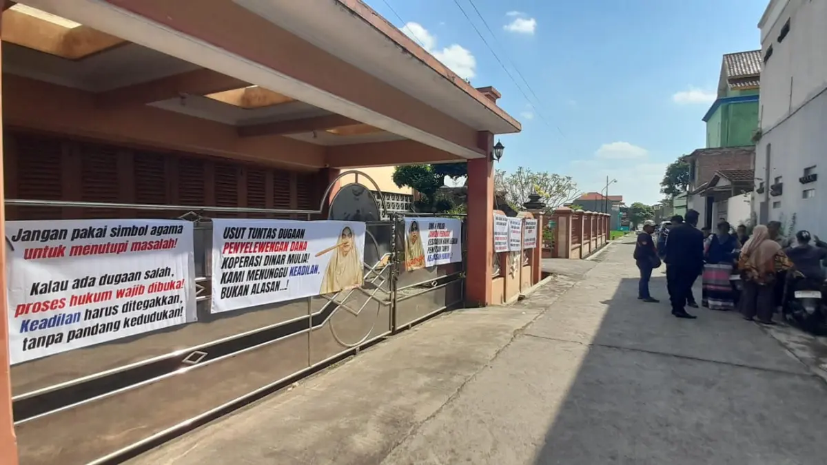 Nasabah memasang spanduk di kediaman pimpinan Koperasi Dinar Mulia di wilayah Cangakan, Karanganyar Kota, Senin (8/6/2026) siang. (Rudi Hartono/Radar Solo)