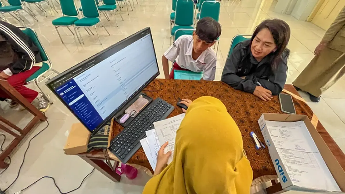 Orang tua mendampingi anaknya saat mendaftar SPMB di SMPN 1 Solo, Selasa (9/6). (M. Ihsan/Radar Solo)