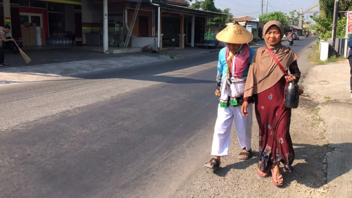 Kakek Mustofa warga Dukuh Krajan RT 11/02, Desa Kedung Ringin, Kecamatan Suruh, Kabupaten Semarang berjalan kaki dari Asrama Haji Donohudan menuju rumahnya, Kamis (11/6/2026). (ABDUL KHOFID/RADAR SOLO) 