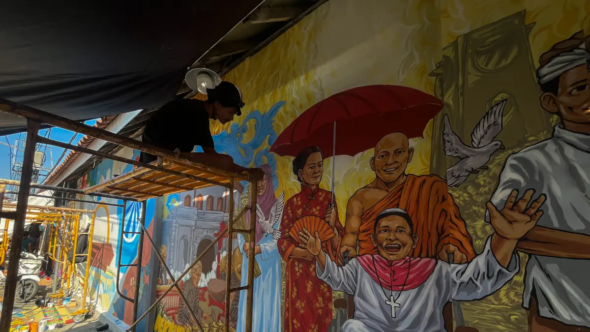 SARAT MAKNA: Seniman tengah mengikuti lomba mural yang digelar dalam rangka Hari Jadi Pemkot Solo ke-80. (M. IHSAN/RADAR SOLO)