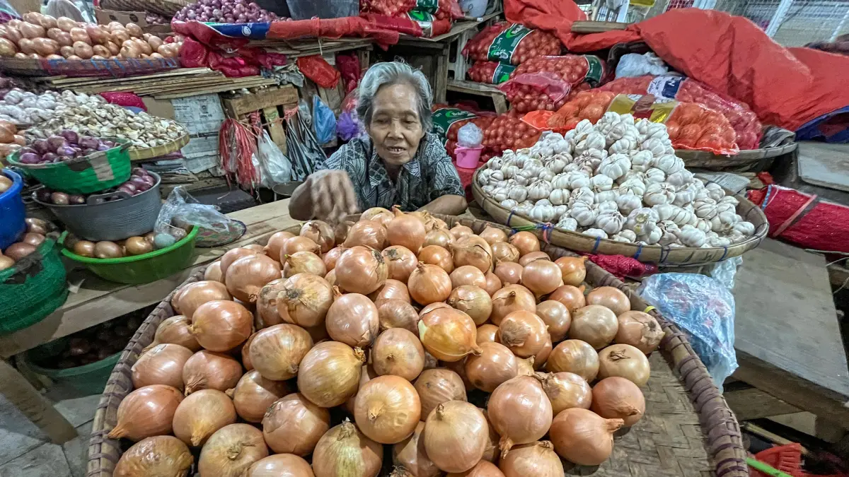 PASRAH: Pedagang bawang di Pasar Legi Solo, Senin (15/6). Harga bawang terpantau merangkak naik di pasaran, yang berdampak turunnya daya beli masyarakat. (M IHSAN/RADAR SOLO)