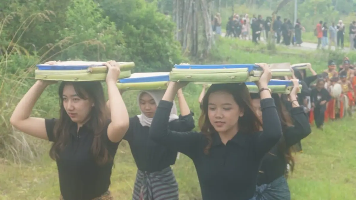 Remaja putri menyunggi jenang manggul untuk disajikan kepada peserta Kirab Pager Banyu di Kampung Siluman, Taman Nasional Gunung Merapi (TNGM) Klaten. (Angga Purenda/Radar Solo)