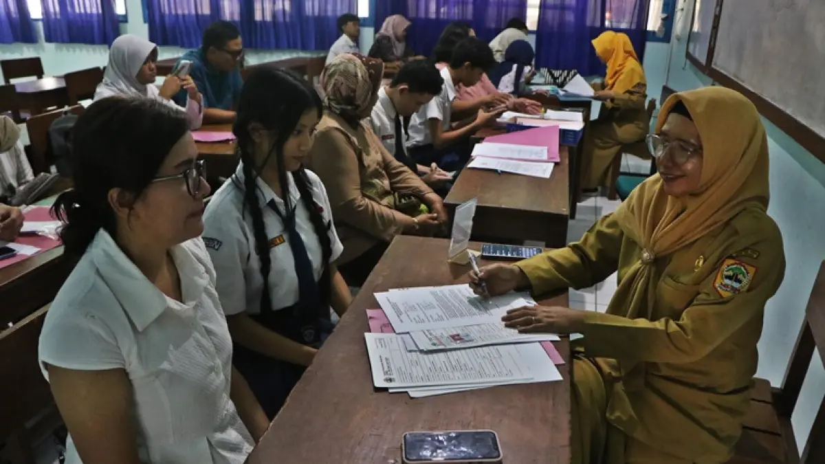 Orang tua mendampingi calon murid baru saat tahapan daftar ulang dalam Seleksi Penerimaan Murid Baru (SPMB) 2026 di SMAN 4 Solo, Senin (22/6). (ARIEF BUDIMAN/RADAR SOLO)