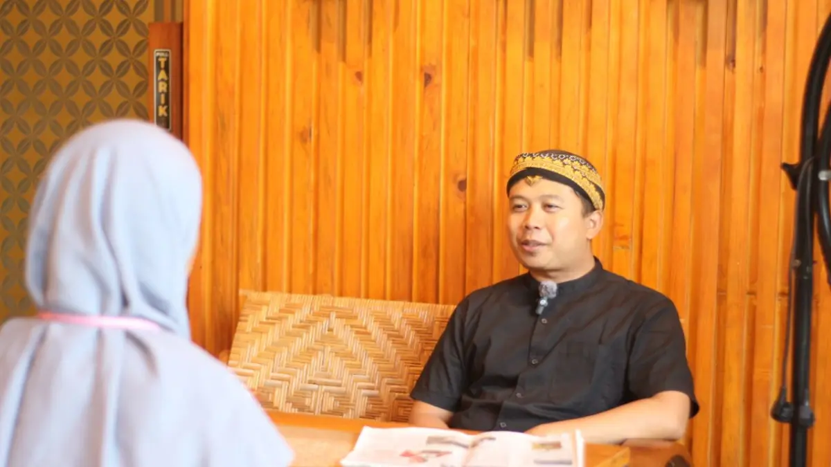 Seorang pengunjung konsultasi dengan Tejo Widodo untuk membacakan primbon. Foto kanan, dinding kafe dihiasi filosofi Jawa. (Luthfiana Sekar/Radar Solo)