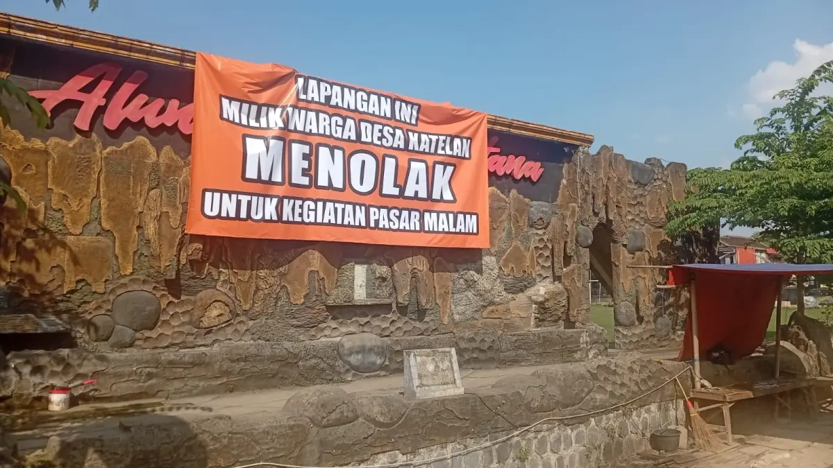 Spanduk desakan pembatalan pasar malam di Lapangan Desa Katelan, Kecamatan Tangen, Sragen. (Ahmad Khairudin/Radar Solo)
