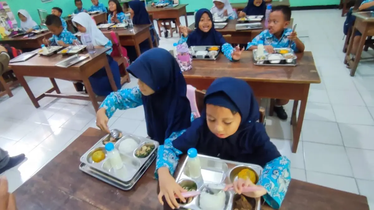 Siswa SD di Sragen menikmati sajian menu makan bergizi gratis (MBG) dari pemerintah. (Ahmad Khairudin/Radar Solo)