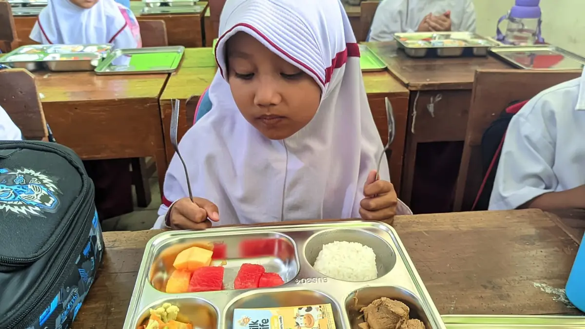 Siswi di Wonogiri menerima MBG. Selama libur sekolah, distrubsi MBG dihentikan. (DOK.IWAN ADI/RADAR SOLO)
