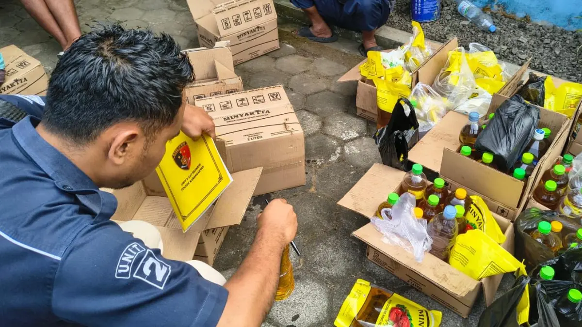 Anggota Satreskrim Polres Karanganyar mengecek Minyakita di Karanganyar yang berbau solar. (Rudi Hartono/Radar Solo)