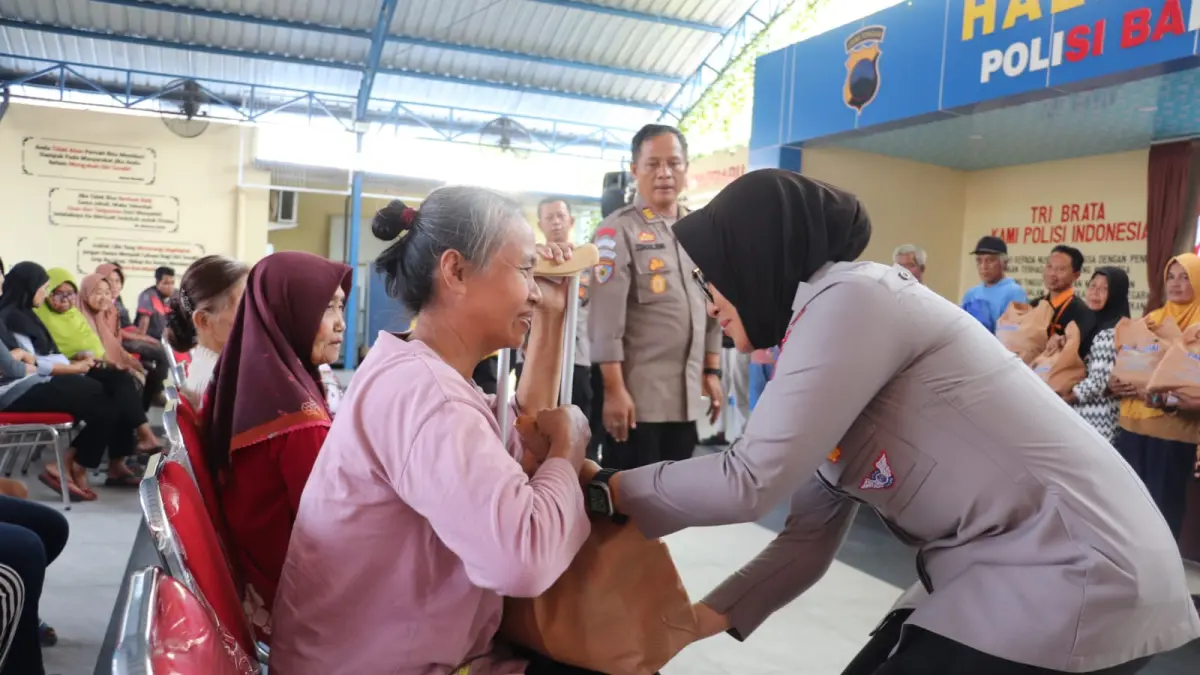 Kapolres Sragen AKBP Dewiana Syamsu Indyasari bagikan paket sembako ke warga, Jumat (26/6/2026). (Ahmad Khairudin/Radar Solo)