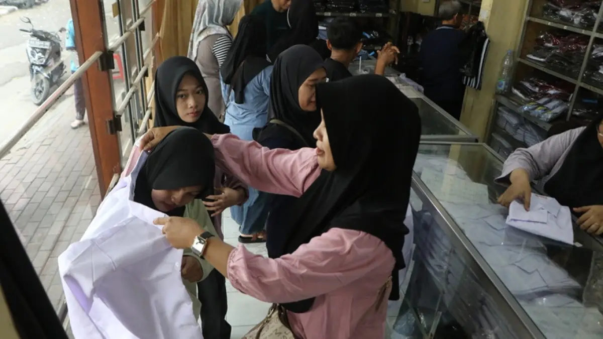 Pembeli mencoba seragam sekolah baru di salah satu toko di Jalan Slamet Riyadi, belum lama ini. (ARIEF BUDIMAN/RADAR SOLO)  
