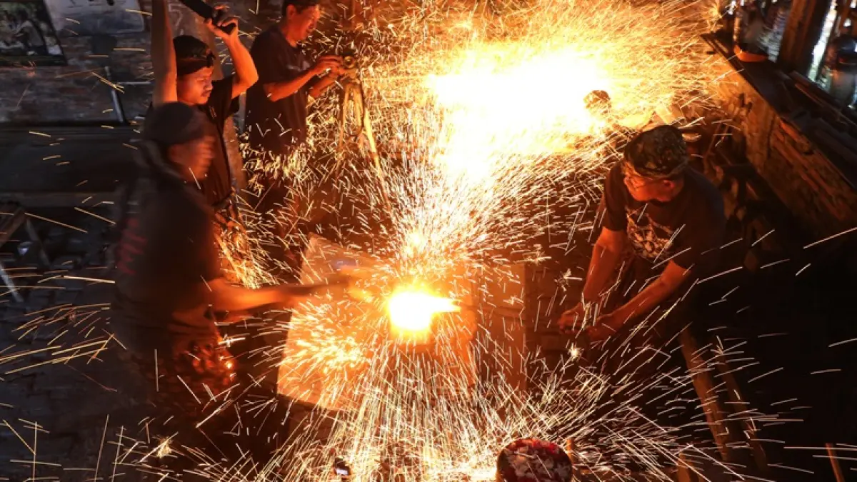 Subandi dibantu beberapa orang menempa keris di Omah Keris, Palur, Karanganyar, Senin (29/6). (ARIEF BUDIMAN/RADAR SOLO)