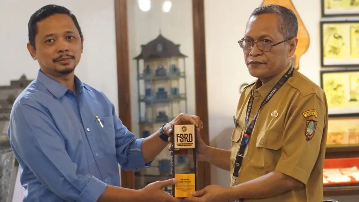 Penyerahan cenderamata dari tim peneliti FSRD UNS kepada perwakilan Museum Radya Pustaka Surakarta. (DOK.FSRD UNS) 