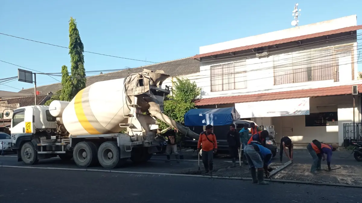 Pekerja menyelesaikan pengecoran beton kurus di Jalan Adi Sumarmo, Kecamatan Kartasura, Rabu (1/7). (IWAN KAWUL/RADAR SOLO)