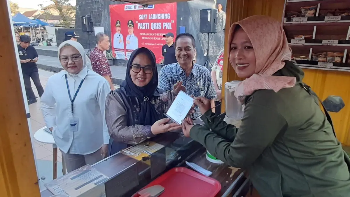 Ketua Komisi B DPRD Karanganyar Latri Sulistyowati (dua dari kiri) mencoba penerapan e-retribusi PKL Taman Pancasila Karanganyar. (Rudi Hartono/Radar Solo)