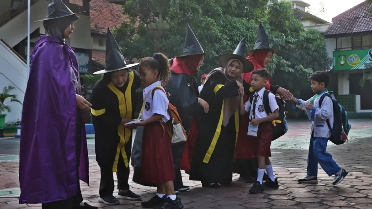 Murid baru SDN Cemara Dua Solo menyalami wali kelas yang berdandan ala tokoh fiksi Harry Potter di hari pertama MPLS di halaman sekolah setempat, Senin (13/7). (ARIEF BUDIMAN/RADAR SOLO)