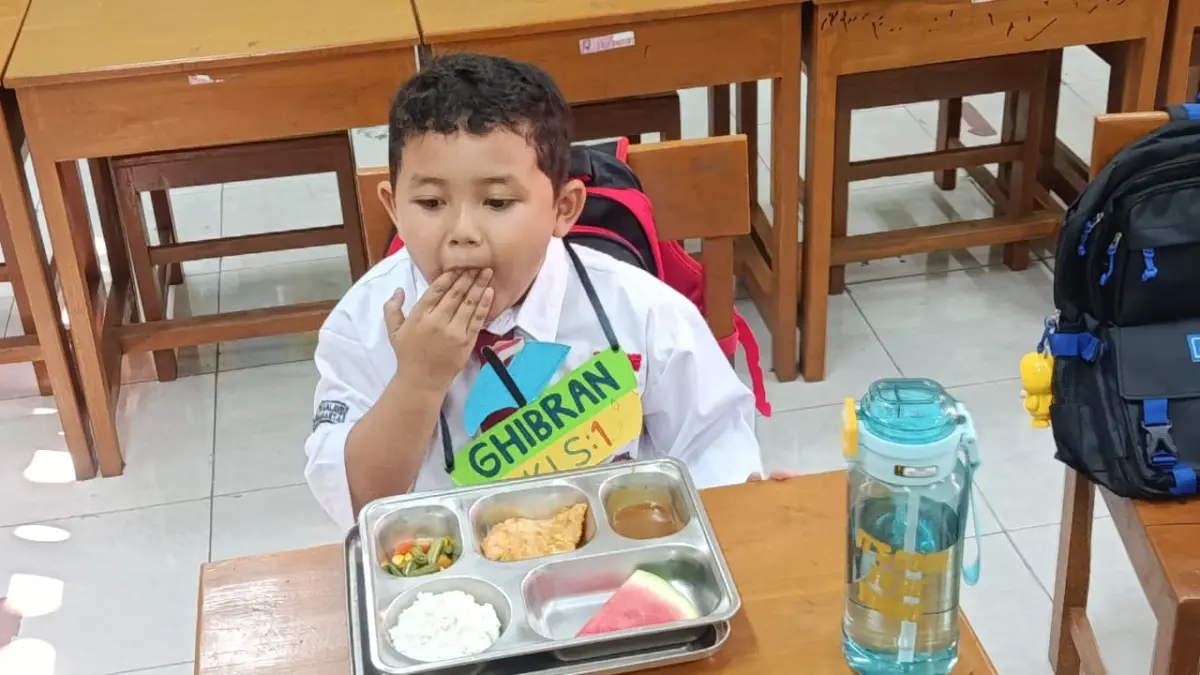 Murid baru SDN Tegalayu Solo menyantap menu MBG di sela MPLS, Senin (13/7). (Alfida Nurcholisah/Radar Solo)