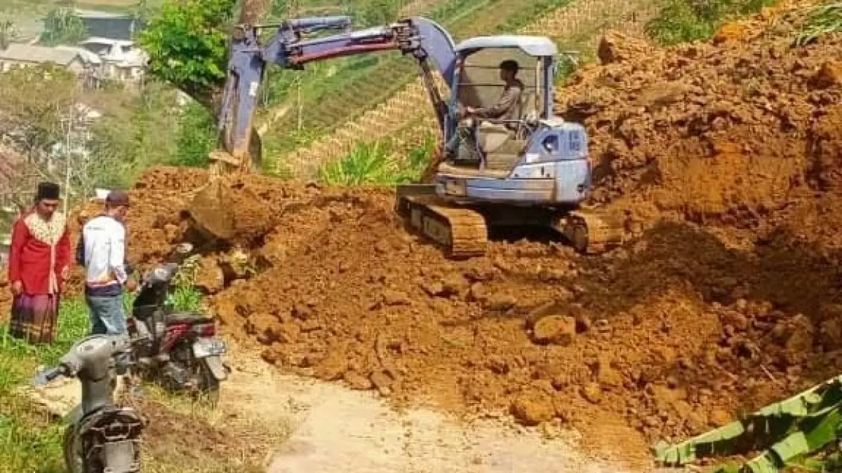 Proses pembersihan longsor yang menutup jalan di Dusun Tawang, Desa Wonorejo, Kecamatan Jatiyoso, Karanganyar, Senin (13/7/2026). (Rudi Hartono/Radar Solo)