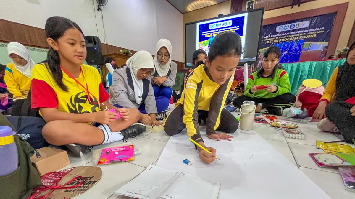 Siswa kelas Program Khusus Kota Solo menulis cita-citanya saat MPLS, Selasa (14/7). (M IHSAN/RADAR SOLO)
