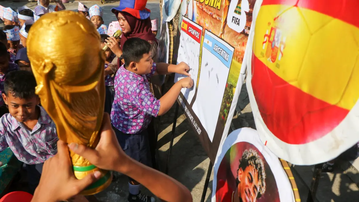 EUFORIA: Siswa SDN Kadipiro melakukan urun cap untuk mendukung juara Piala Dunia 2026. (ARIEF BUDIMAN/RADAR SOLO) 