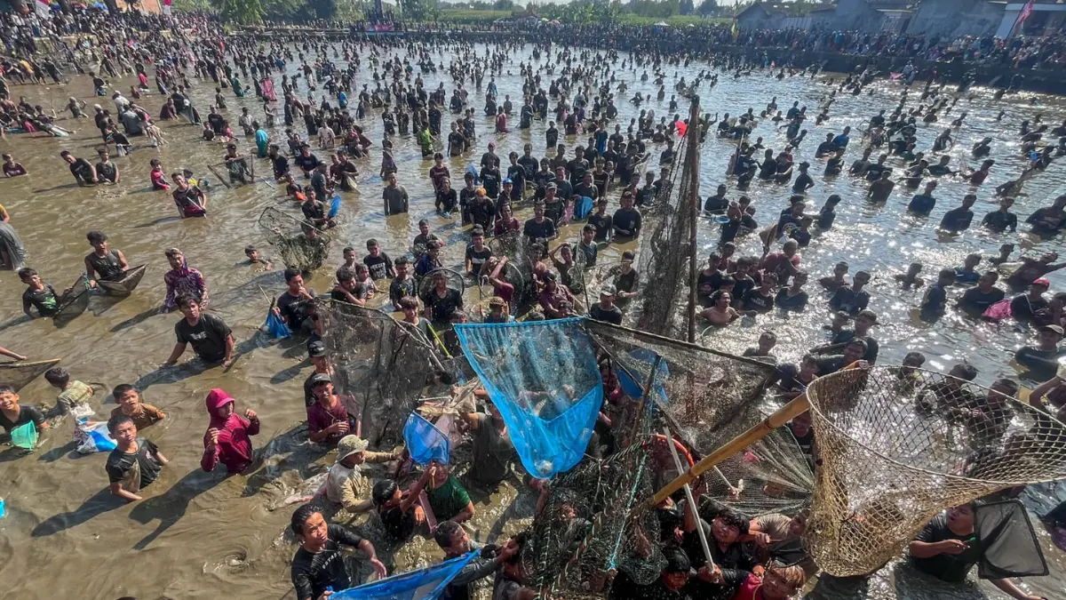 Ribuan warga berebut ikan dalam Festival Memet Ikan di Kolam Desa Gemblegan, Kecamatan Kalikotes, Klaten, Minggu (19/8/2026). (M.Ihsan/Radar Solo)

