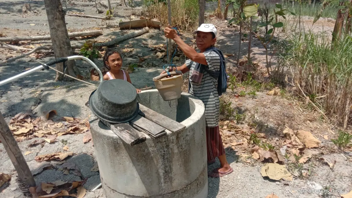 Warga Desa Galeh, Kecamatan Tangen, Sragen mengais air bersih dari sumur mereka yang mulai mengering, Minggu (19/7/2026). (Ahmad Khairudin/Radar Solo)