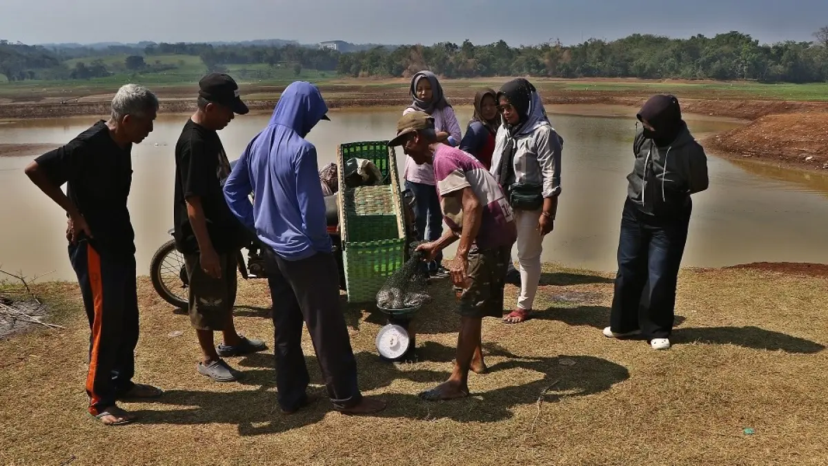 Warga menjual ikan hasil tangkapan di dasar Waduk Delingan, Karanganyar yang mengering selama kemarau, Senin (20/7/2026). (Arief Budiman/Radar Solo)