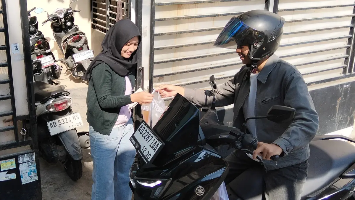 Driver Anjem mengantar makanan bagi mahasiswa yang kos di sekitar kampus UNS Solo. (ANMER JILVANDIS/RADAR SOLO)