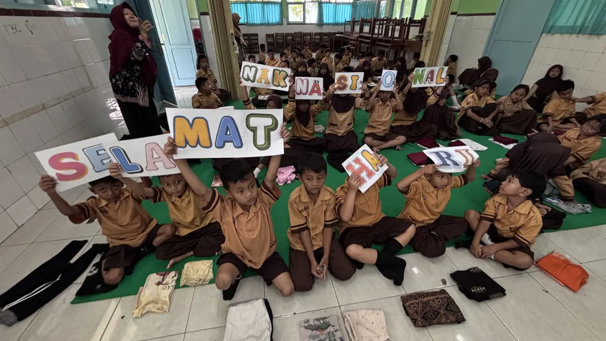 Murid SDN Tegalayu Solo mengangkat banner Hari Anak Nasional, Rabu (23/7). (ARIEF BUDIMAN/RADAR SOLO)